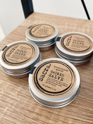 Four tins of Frankincense & Myrrh Sacred Salve handcrafted with Premium Omani frankincense, myrrh, and nourishing natural ingredients for daily skin care.