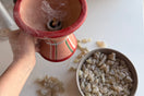 Person holding a traditional Omani frankincense burner with Premium Hojari Boswellia sacra frankincense resin, releasing its natural aromatic fragrance.