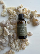 30 ml bottle of Premium Omani Hojari Frankincense Essential Oil displayed with authentic Boswellia sacra frankincense resin on a table, sourced from the Dhofar region of Oman.