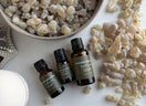 10 ml, 15 ml, and 30 ml bottles of Premium Omani Hojari Frankincense Essential Oil displayed with authentic Boswellia sacra frankincense resin from Dhofar, Oman.